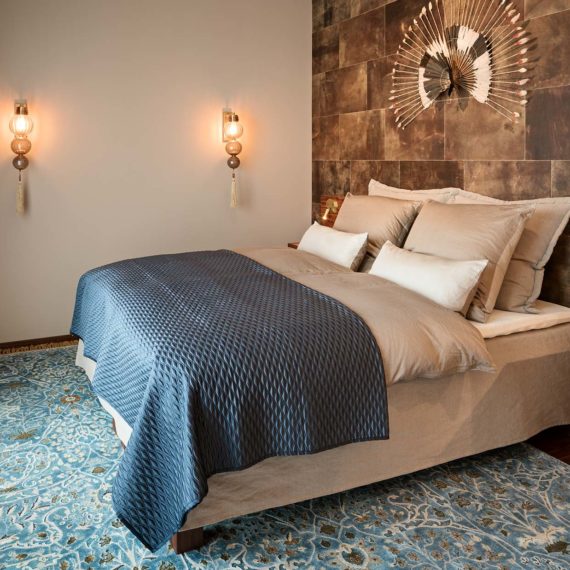 Penthouse Fünf Morgen: Luxuriöses Schlafzimmer mit metallfreiem Bio Boxspringbett und markanter Lederwand
